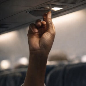 woman presses the call button during flight - health anxiety during flying
