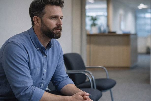 man sitting in an office before a job interview - professional performance anxiety