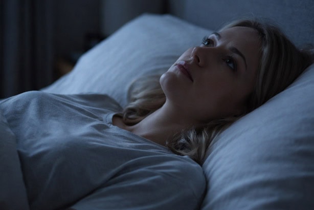woman lying in bed awake staring at the ceiling - sleep anxiety